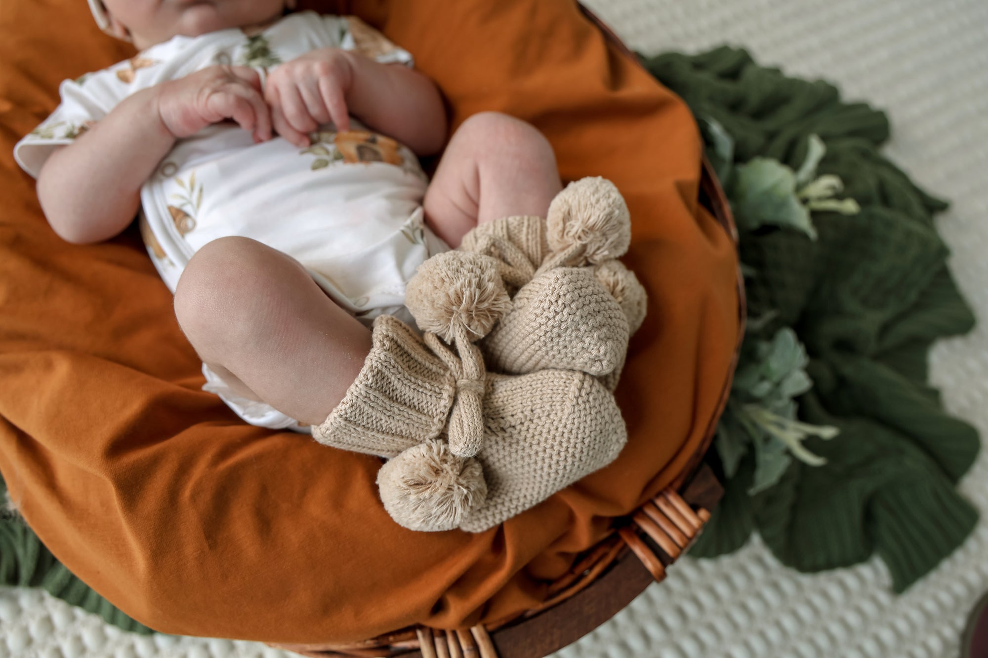 Soft hazelnut organic cotton knit baby booties designed to keep newborn feet warm and comfortable, featuring a timeless neutral colour for everyday wear or gifting.