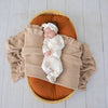 Baby wearing the Up & Away organic cotton zip footie with a hot air balloon print, featuring a two-way zip and enclosed feet for soft, comfortable day and night wear.