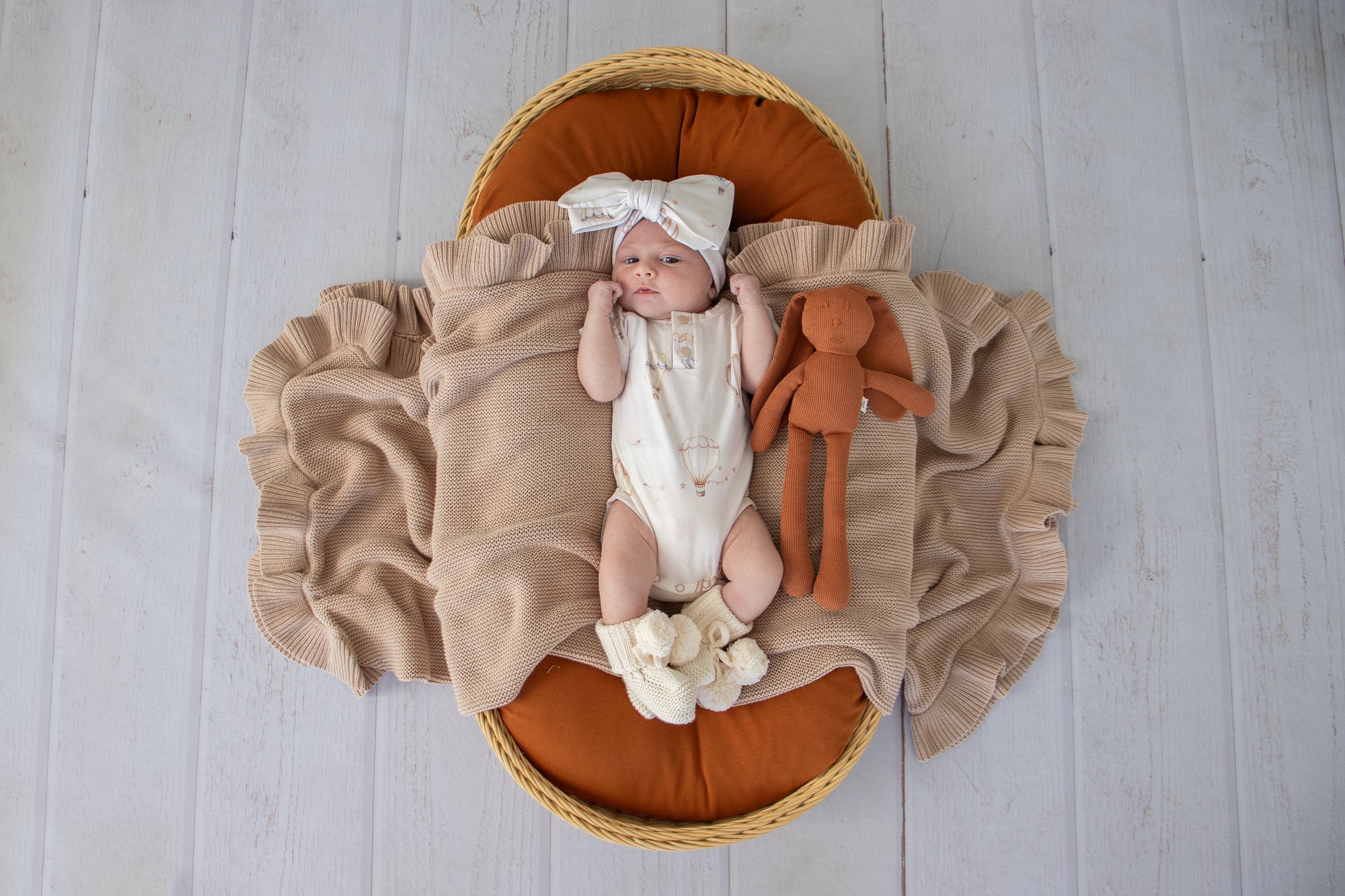 Soft cream organic cotton knit baby booties designed to keep newborn feet warm and comfortable, featuring a timeless neutral colour perfect for everyday wear or gifting.