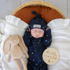 Baby wearing the Starry Night organic cotton convertible romper with fold-over feet and mittens, featuring a soft star print for comfortable day and night wear.