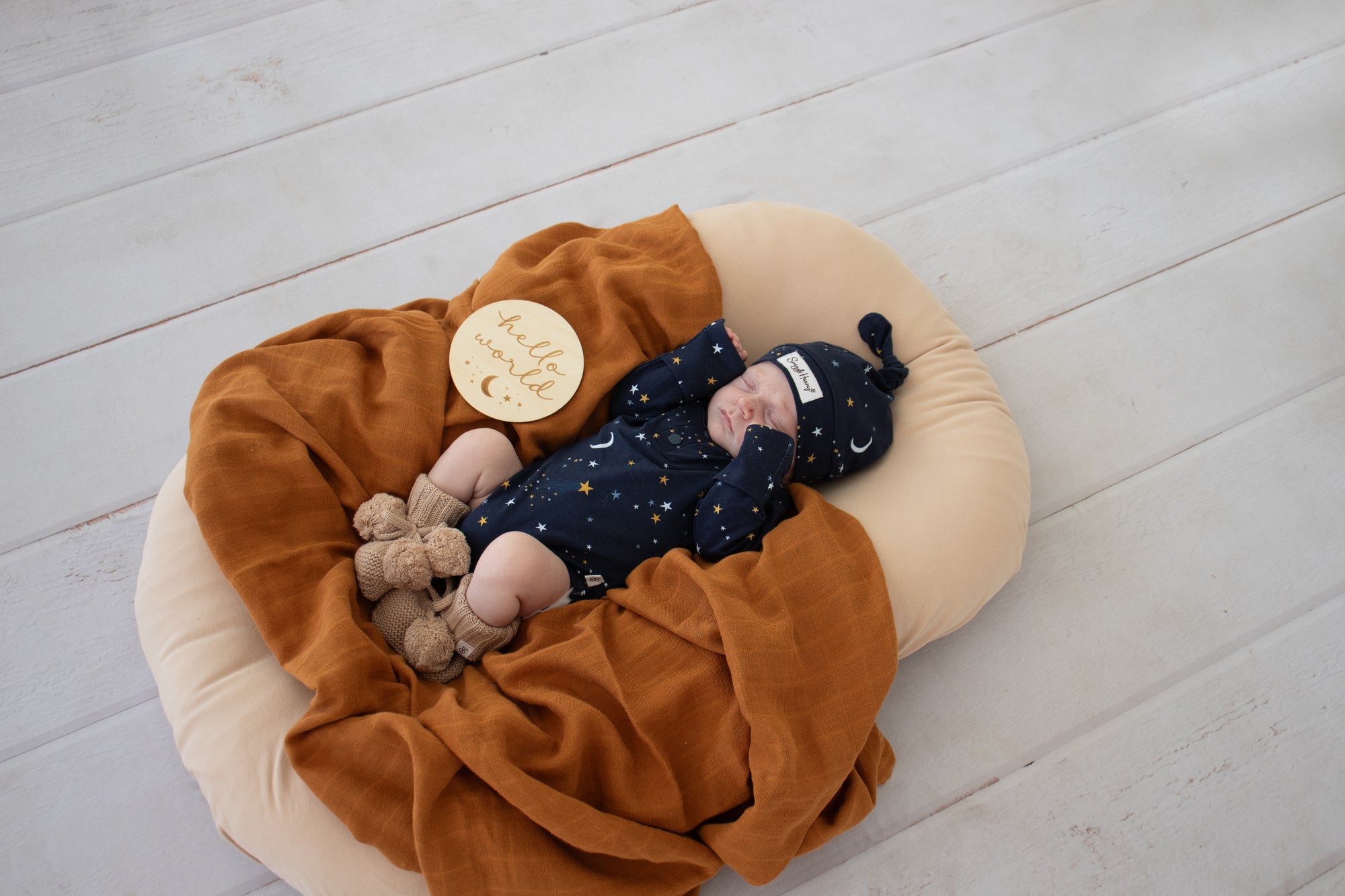 Soft hazelnut organic cotton knit baby booties designed to keep newborn feet warm and comfortable, featuring a timeless neutral colour for everyday wear or gifting.