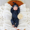 Baby wearing the Starry Night organic cotton convertible romper with fold-over feet and mittens, featuring a soft star print for comfortable day and night wear.