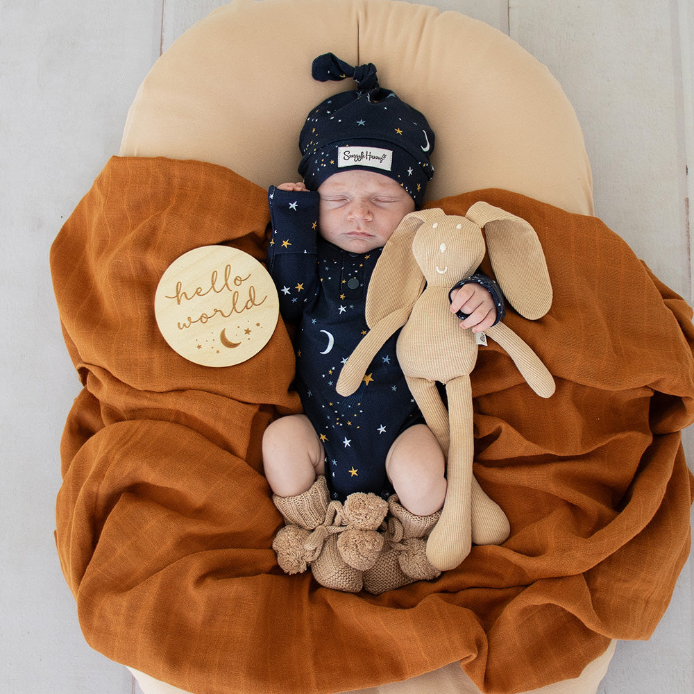 Soft hazelnut organic cotton knit baby booties designed to keep newborn feet warm and comfortable, featuring a timeless neutral colour for everyday wear or gifting.