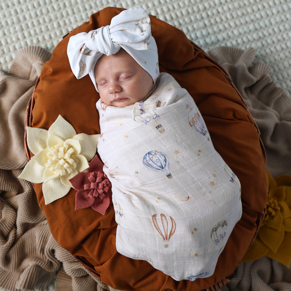 Soft Up & Away organic muslin wrap featuring a charming hot air balloon print, made from breathable organic cotton for swaddling, pram outings, feeding and everyday baby comfort.