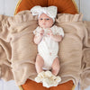 Soft cream organic cotton knit baby booties designed to keep newborn feet warm and comfortable, featuring a timeless neutral colour perfect for everyday wear or gifting.