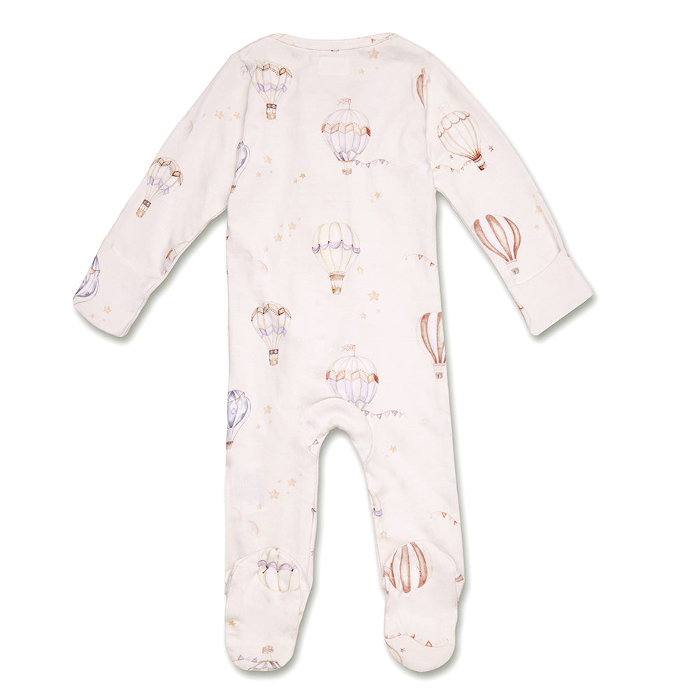 Baby wearing the Up & Away organic cotton zip footie with a hot air balloon print, featuring a two-way zip and enclosed feet for soft, comfortable day and night wear.