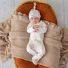 Baby wearing the Up & Away organic cotton zip footie with a hot air balloon print, featuring a two-way zip and enclosed feet for soft, comfortable day and night wear.